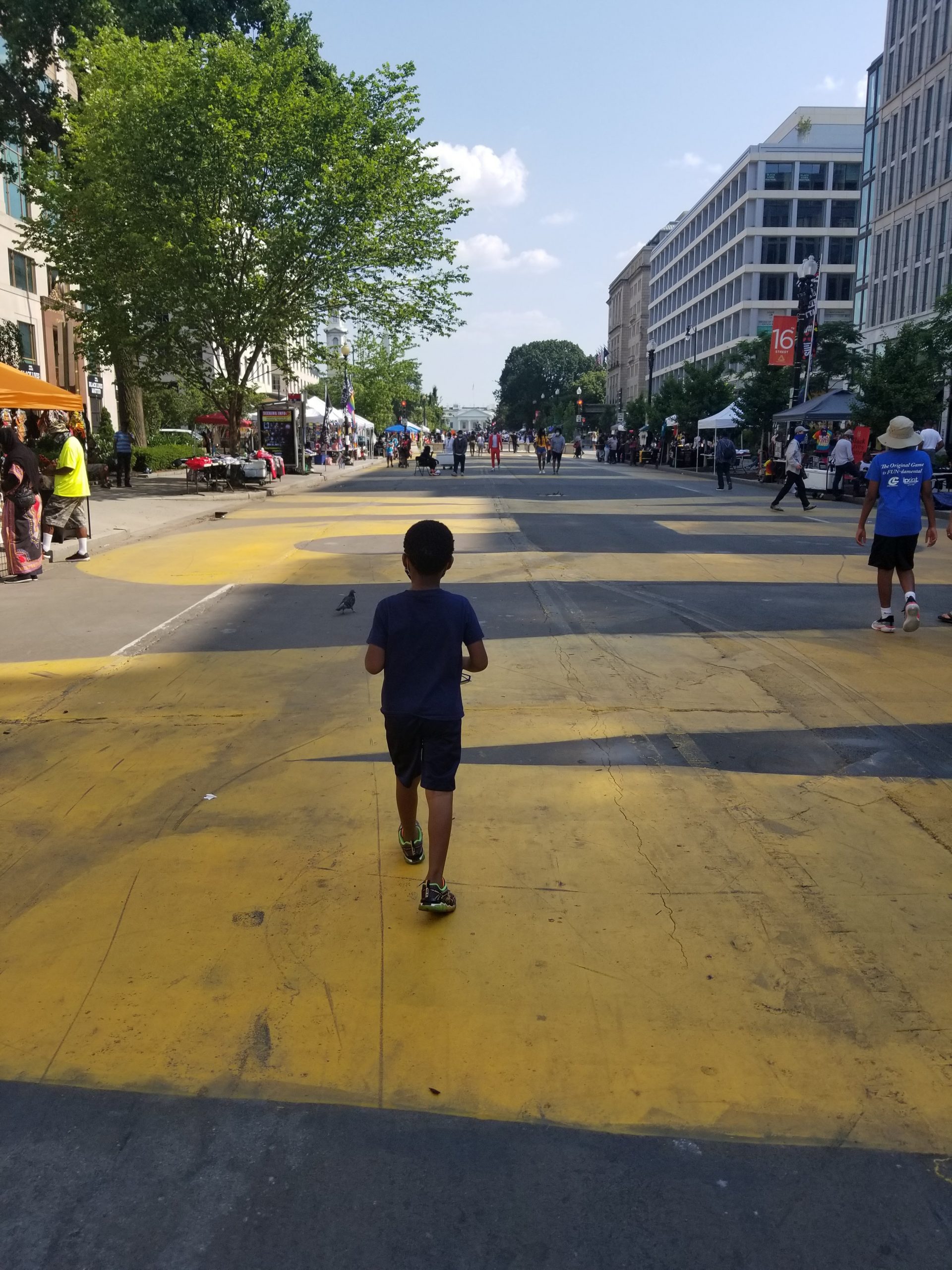 Little boy running on Black Lives Matter Plaza